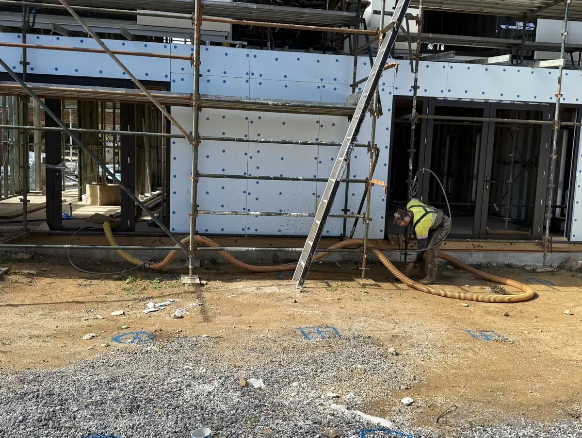 Excavation beside a building under scaffolding