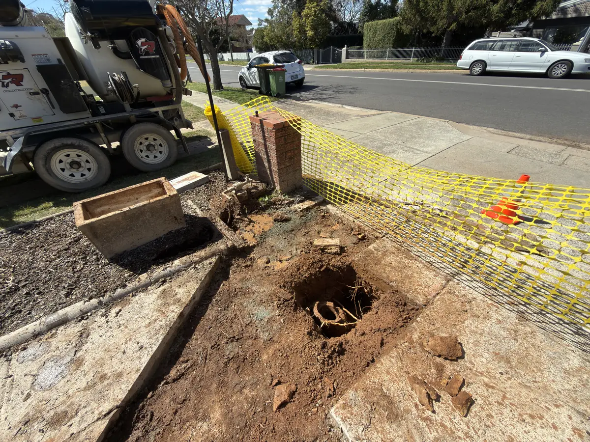 Excavation work beside a residential street with the vacuum trailer