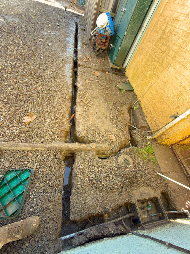 Tight-access excavation beside a building and existing paved surface